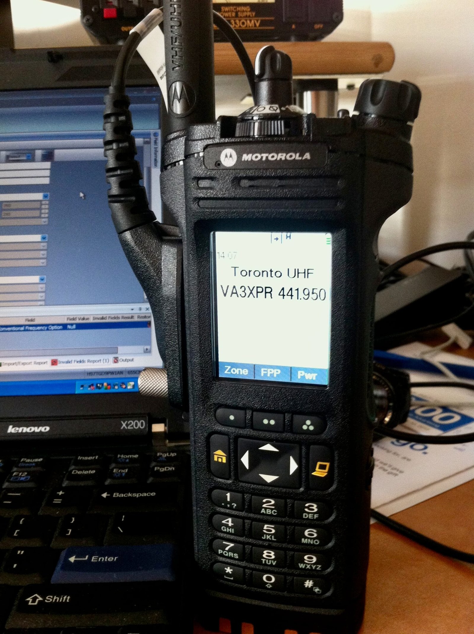 Motorola APX 7000 connected to a laptop for programming via Motorola CPS software.