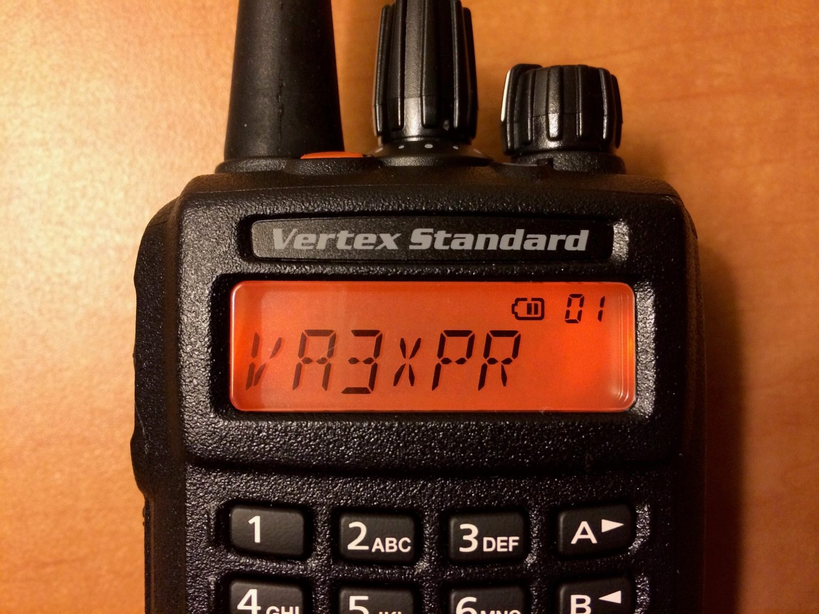 Close-up of the Vertex Standard EVX-539 radio’s monochrome orange display showing channel information.