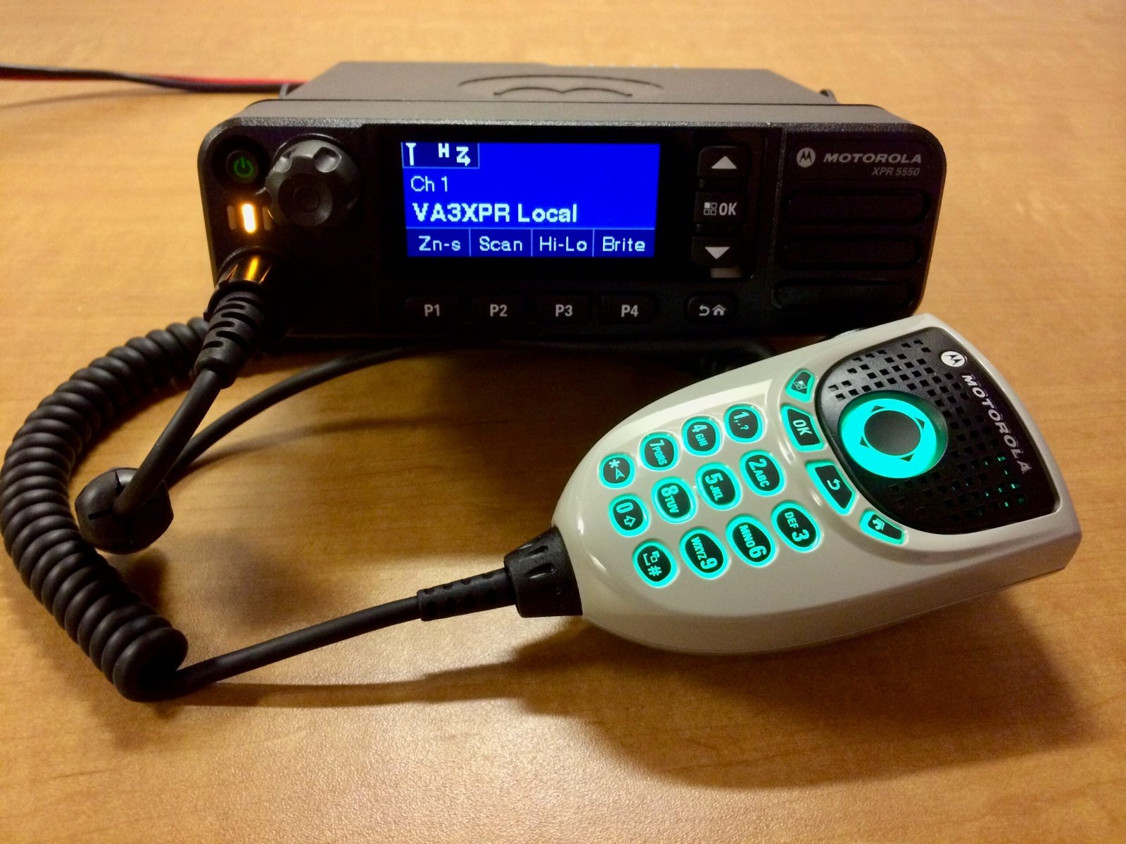Motorola XPR 5550 DMR mobile radio with matching DTMF microphone, showing front panel and color display.