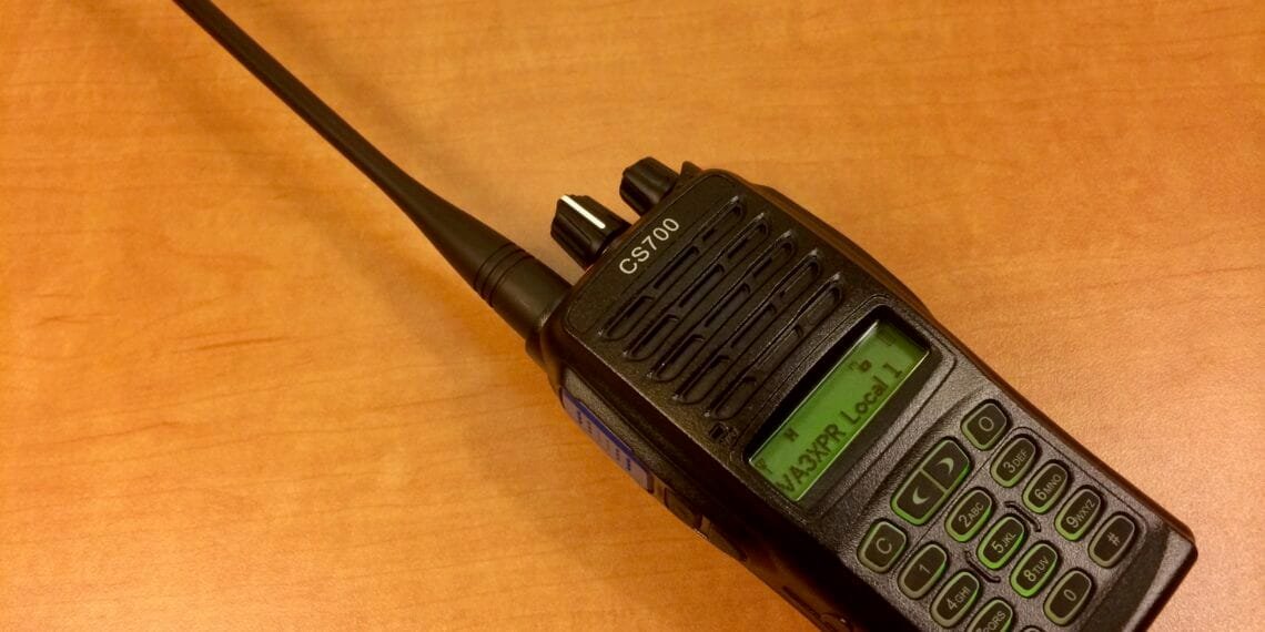 A Connect Systems CS700 handheld DMR radio showing its front display, keypad, and PTT button on the side.