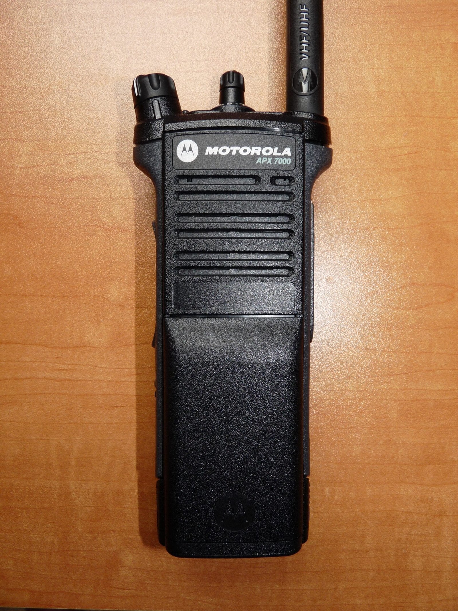 Close-up view of the Motorola APX 7000 radio’s speaker side, featuring the audio grill, side buttons, and textured casing.