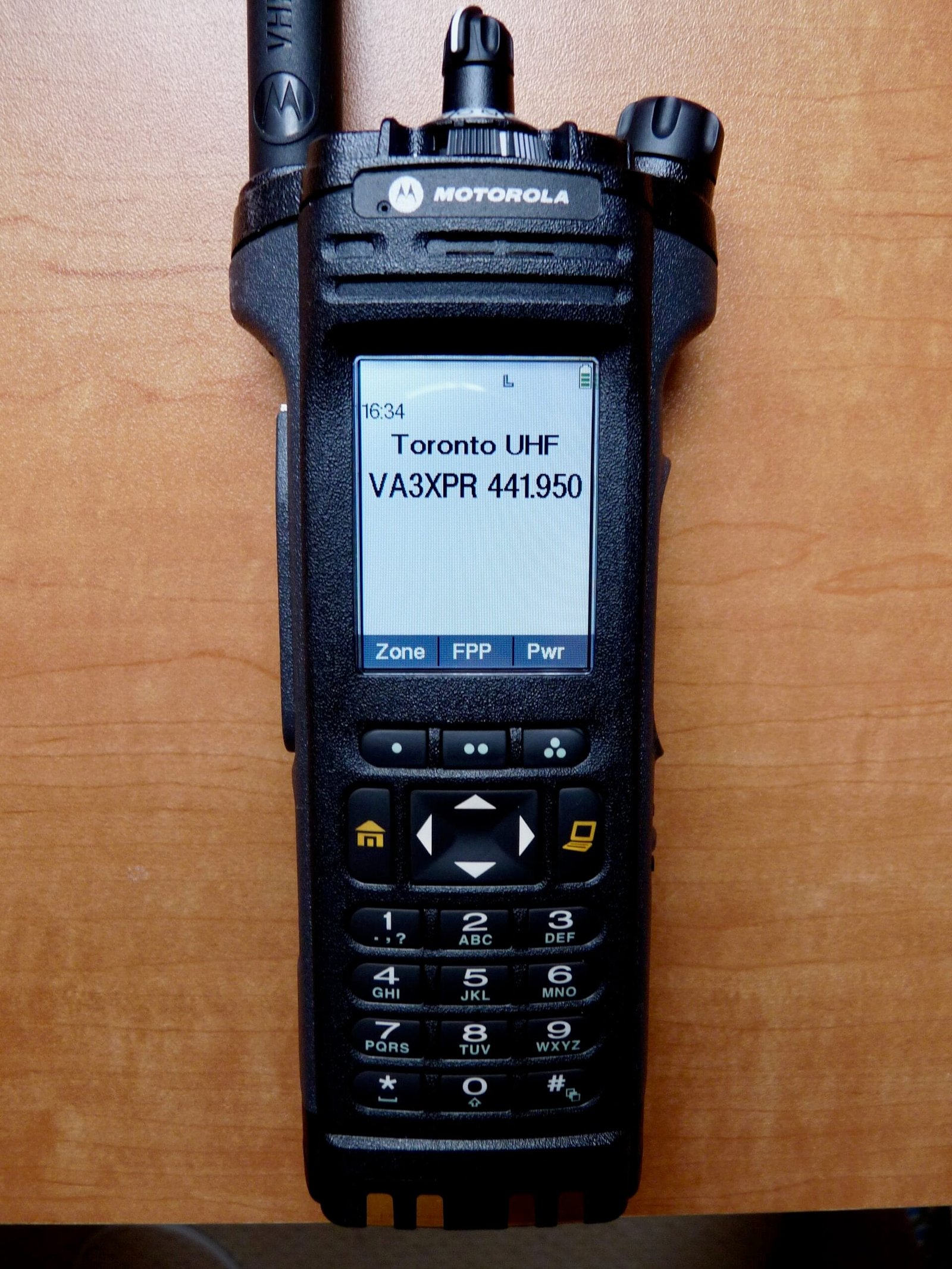 Front-facing Motorola APX 7000 handheld radio displaying keypad and LCD screen.