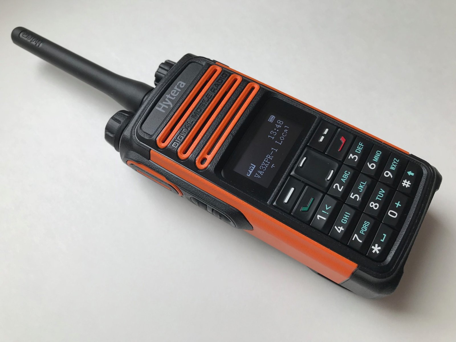 Hytera handheld DMR radio with orange trim, often repurposed by amateur radio operators for digital voice in ham radio.