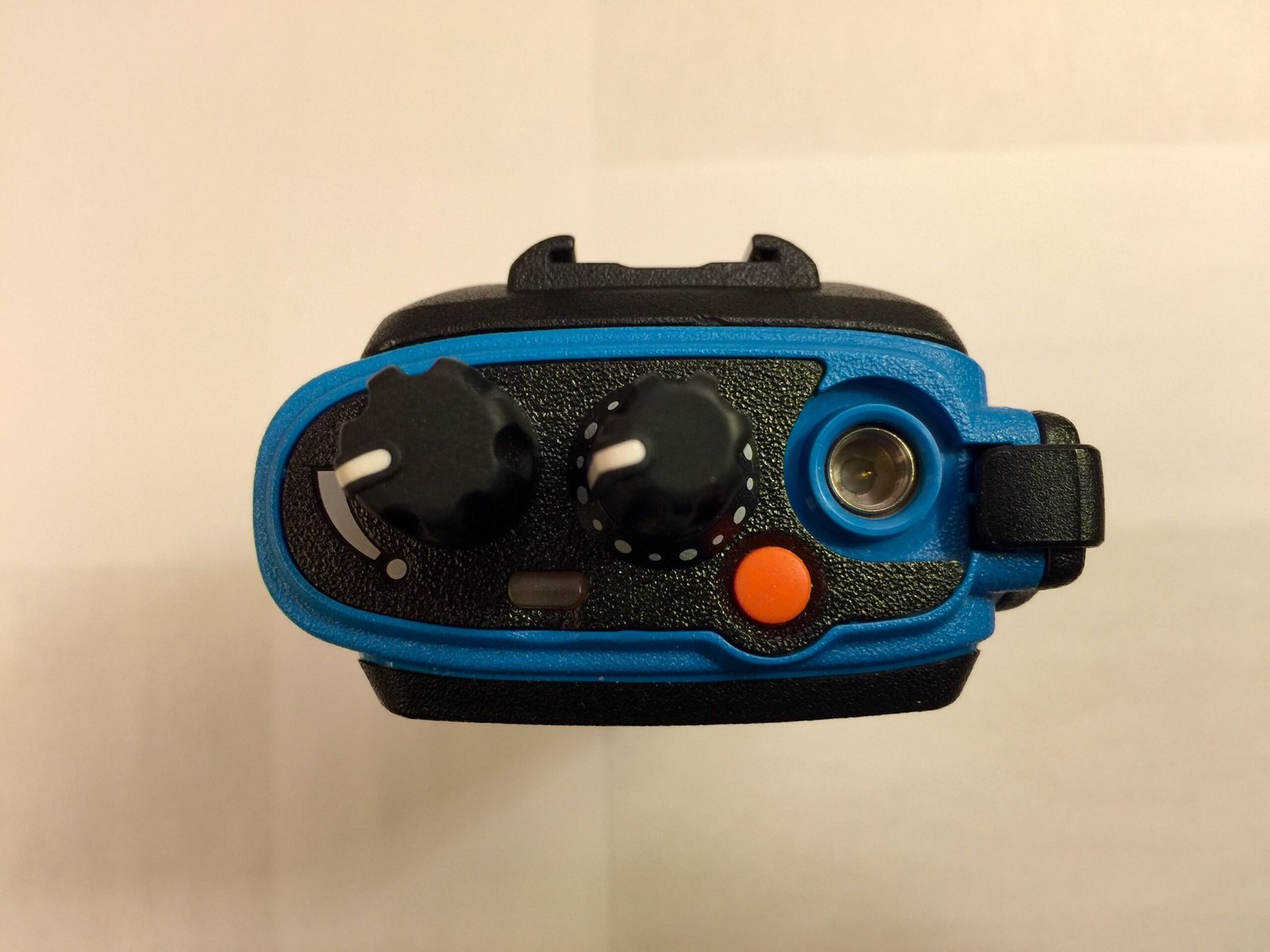 Top view of Motorola XPR7550 IS showing volume knob, channel selector, orange button, and SMA antenna connector