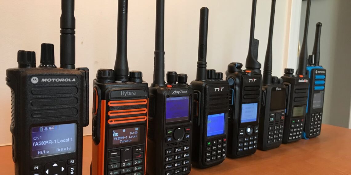 A row of DMR handheld radios from Motorola, Hytera, AnyTone, BFDX, and Radioddity displayed on a desk - perfect for illustrating What Is DMR in Ham Radio.