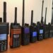 A row of DMR handheld radios from Motorola, Hytera, AnyTone, BFDX, and Radioddity displayed on a desk - perfect for illustrating What Is DMR in Ham Radio.