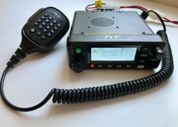 TYT MD-9600 dual-band DMR mobile radio with microphone and display powered on.