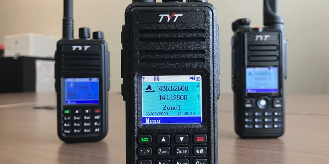 TYT MD-UV380 dual-band DMR handheld radio front view with MD-380 and MD-2017 models in background.
