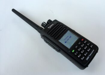 TYT MD-390 waterproof DMR handheld radio with whip antenna and illuminated colour LCD screen.