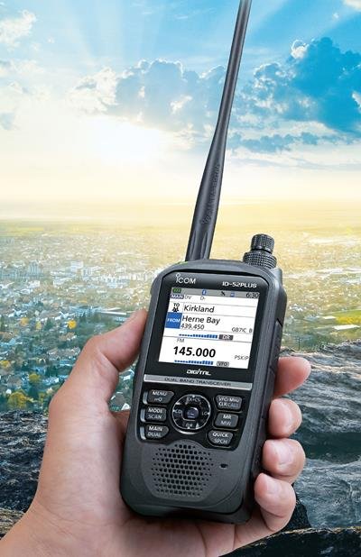 D-STAR for Beginners - Icom ID-52A PLUS handheld D-STAR radio held outdoors overlooking a city, showing digital voice frequency display. Photo credit Icom Inc.