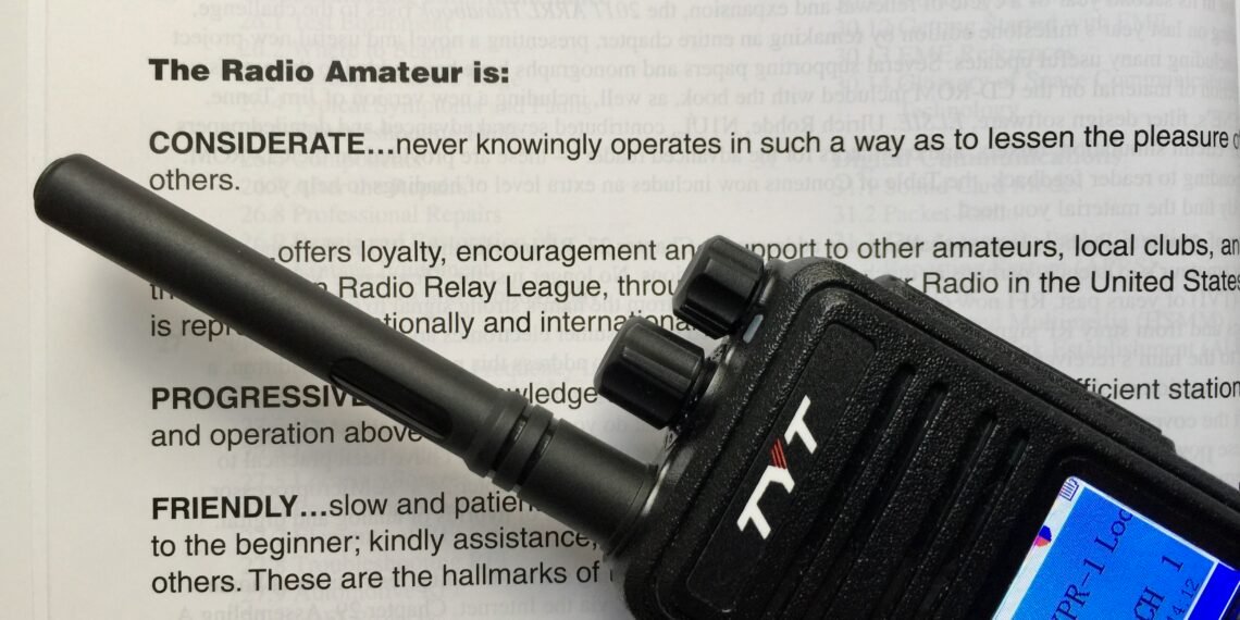 Digital voice handheld radio sitting on top of the original Radio Amateur’s Code document.