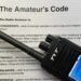 Digital voice handheld radio sitting on top of the original Radio Amateur’s Code document.