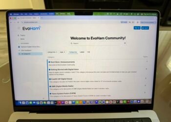 A laptop showing the EvoHam Community ham radio digital voice forum with categories for FreeDV, DMR and Yaesu System Fusion.