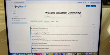 A laptop showing the EvoHam Community ham radio digital voice forum with categories for FreeDV, DMR and Yaesu System Fusion.